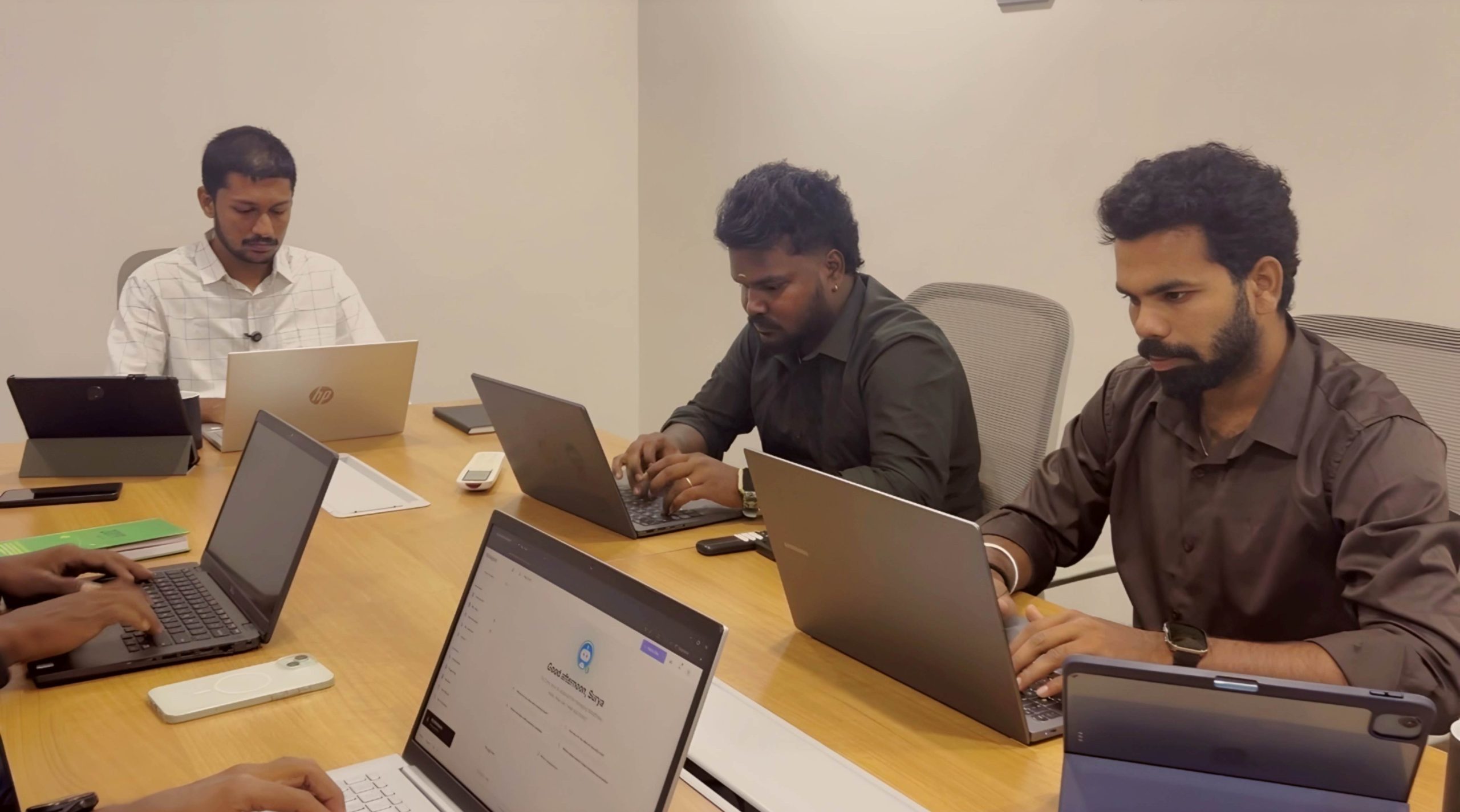 Siteligent team collaborating on laptops and tablets, supporting WordPress website management.